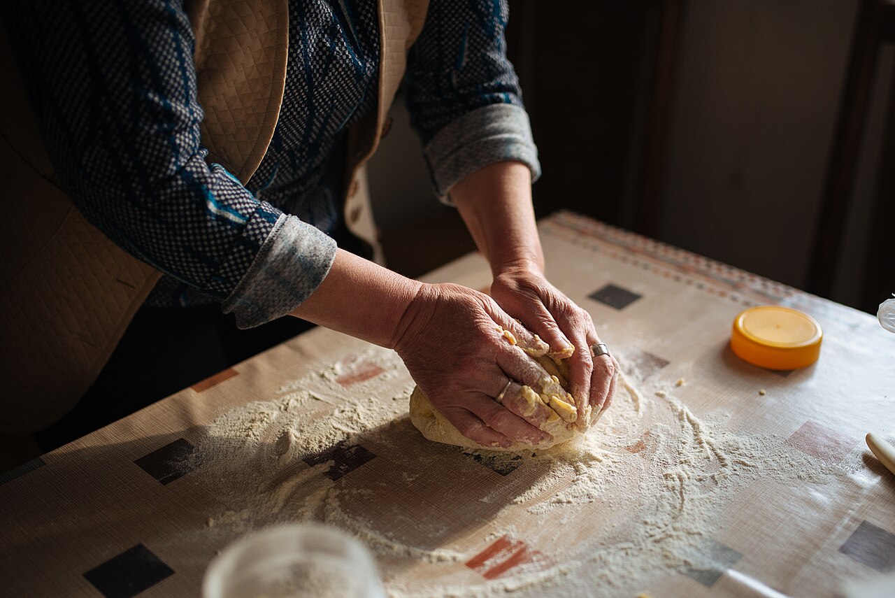 Mains de boulangère pétrissant la pâte